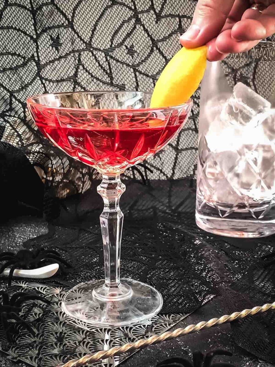Slide the lemon zest into the cocktail glass.