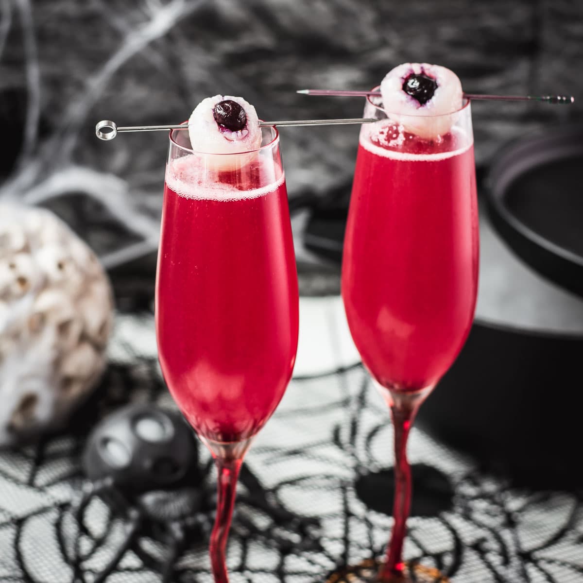 Spooky red Halloween cocktails, garnished with lychee eyeballs and served in a spooky location.