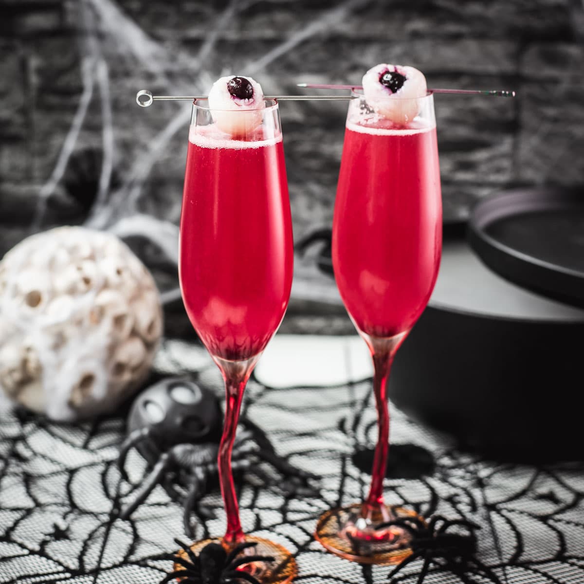 Spooky red Halloween cocktails, garnished with lychee eyeballs and served in a spooky location.