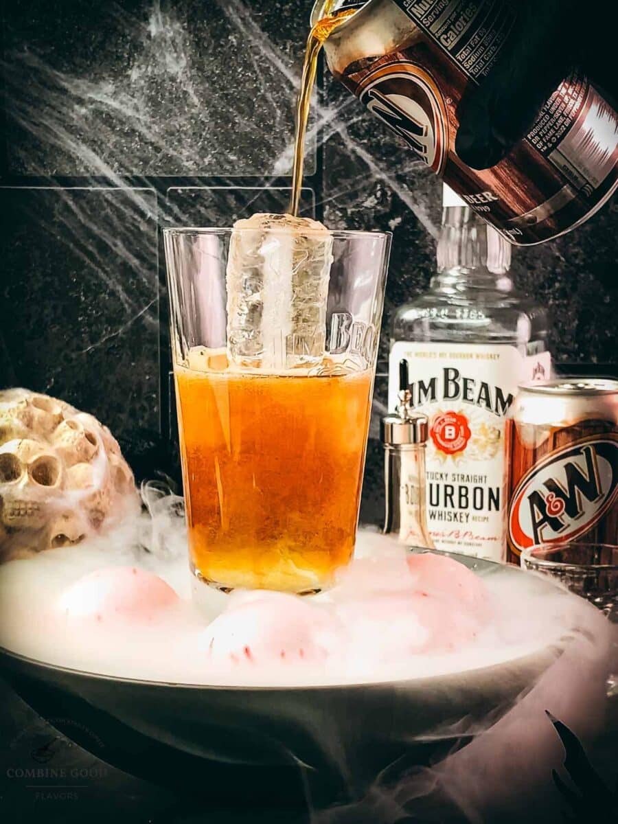 Chilled root beer being poured into bourbon and ice.