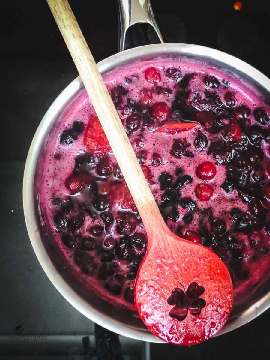 Cooked cranberry and mixed berry syrup in a saucepan after simmering