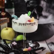 Poison apple margarita with black sugar and gummy worm garnish