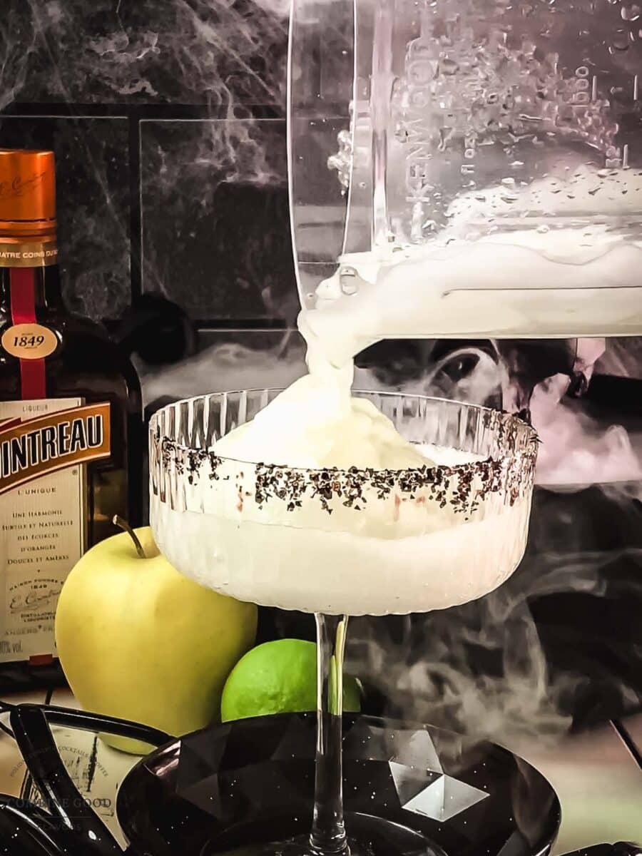 Frozen green margarita poured into a black sugar-rimmed glass
