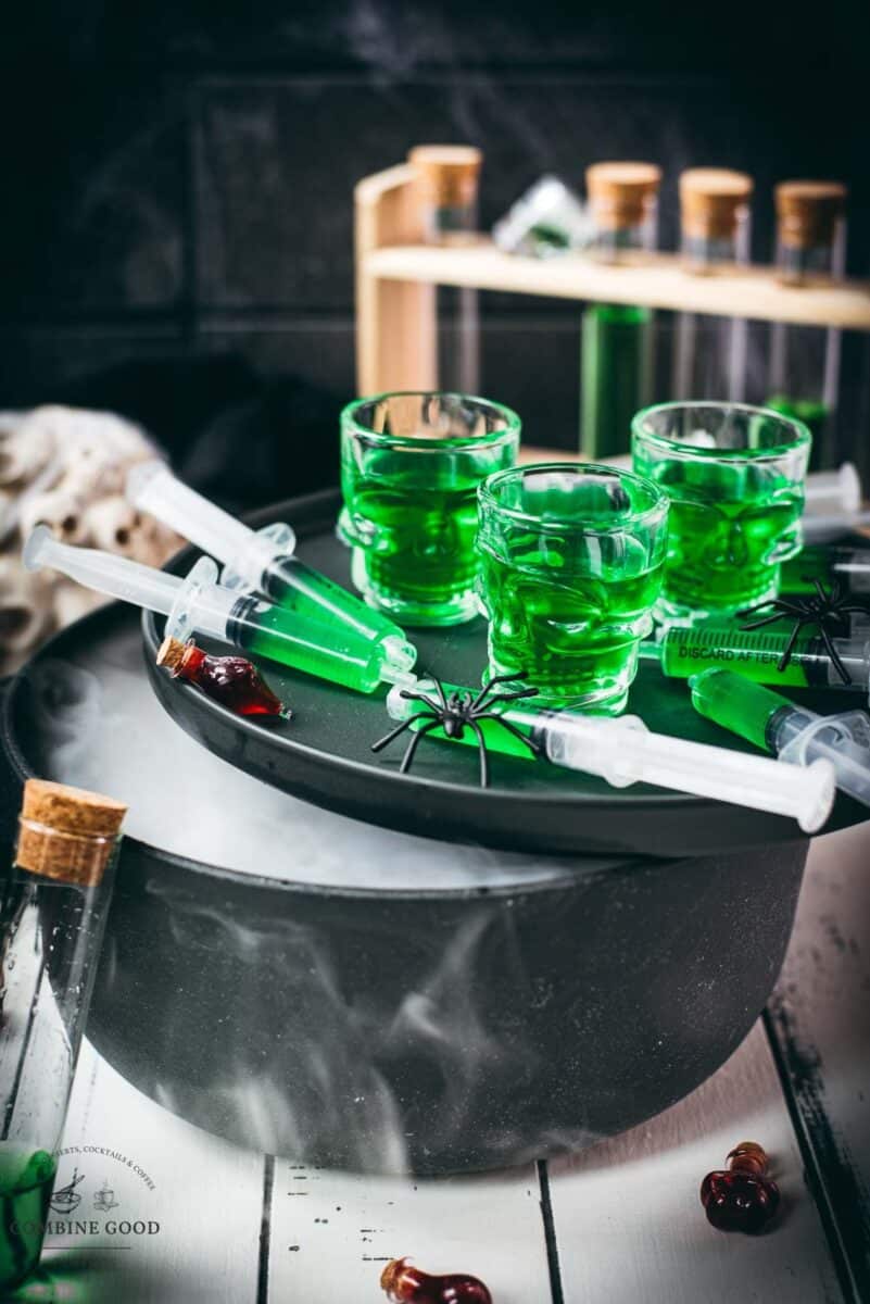 Toxic green Halloween Jello shot syringes with skull-shaped shot glasses