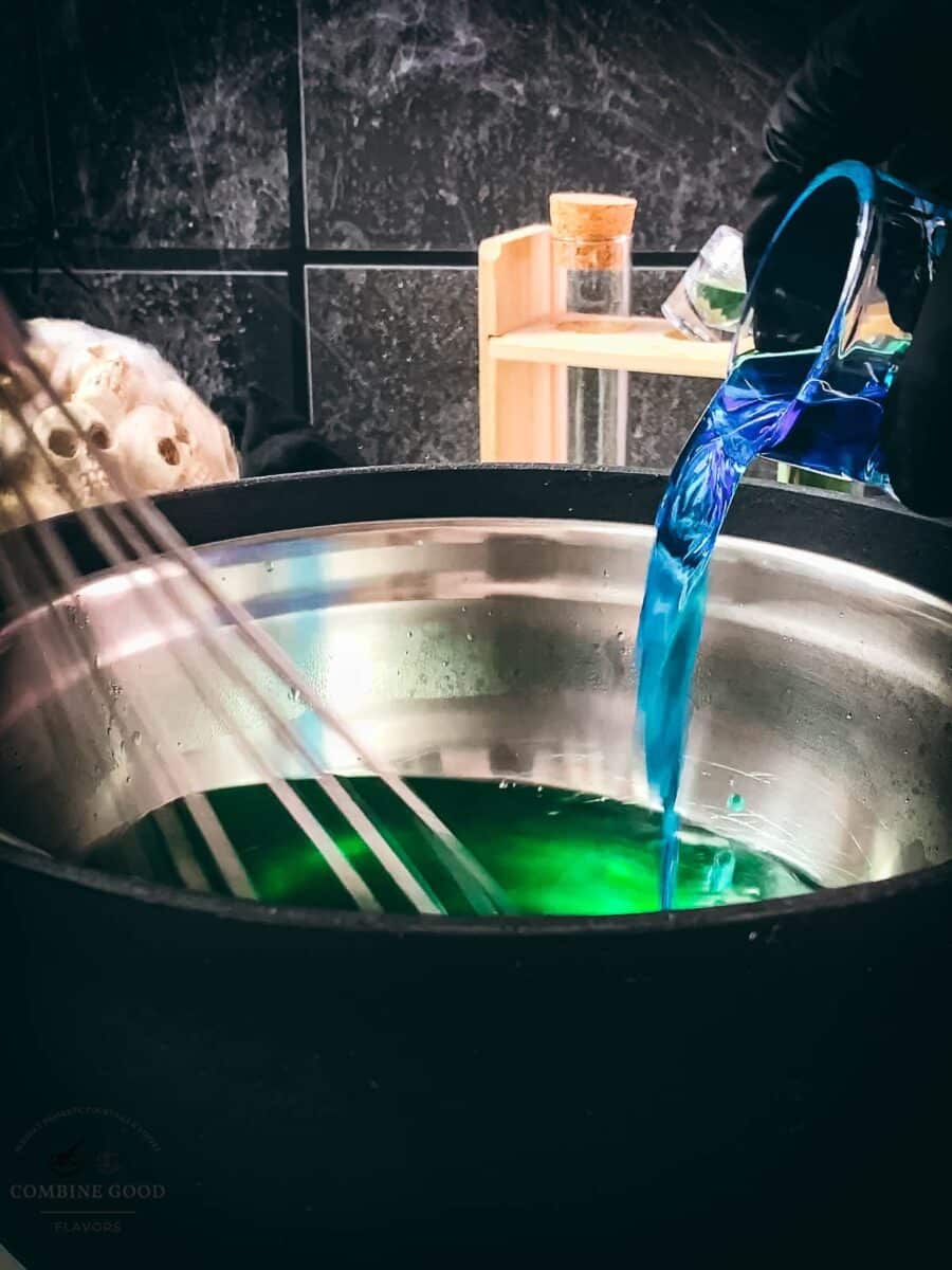 Pouring alcohol into green Halloween Jello shot mixture