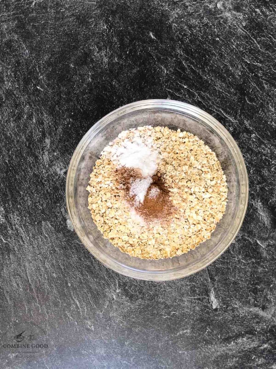 Flour, baking soda, salt, cinnamon, and rolled oats combined in a mixing bowl.