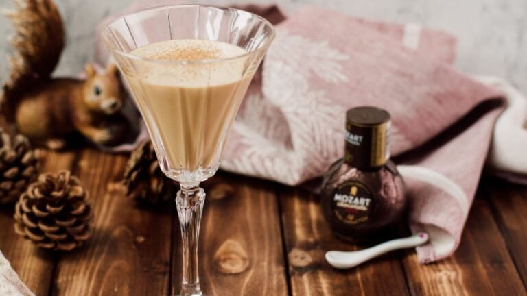 Dark chocolate Brandy Alexander beside a bottle of Mozart Dark Chocolate Liqueur