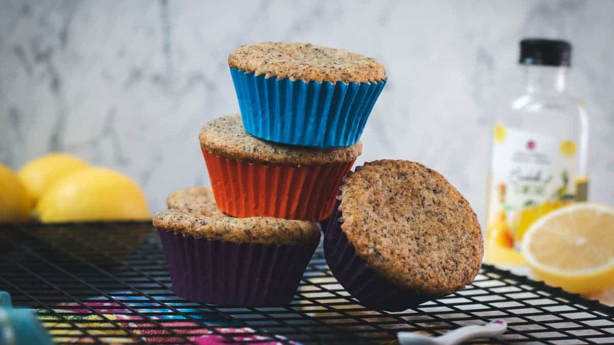 A cute little tower of lemon poppy seed muffins, arranged on a cooling rack.