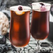 Spooky black velvet cocktail, garnished with eerie lychee eyeballs.
