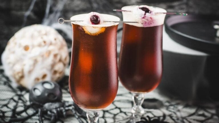 Spooky black velvet cocktail, garnished with eerie lychee eyeballs.