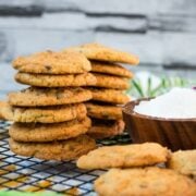 Delicious coconut chocolate chip cookies, stacked on a wooden plate.