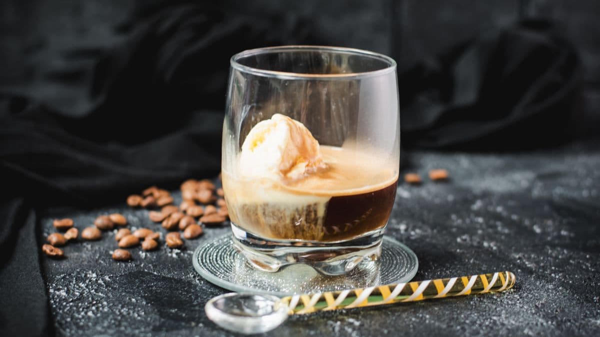This photo shows a glass with an affogato, featuring a scoop of vanilla ice cream floating in espresso.