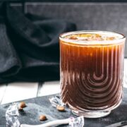 Stunning and delicious iced Americano, served in a gorgeous glass and placed on a black slate plate.