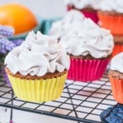 Ready to serve orange muffins with lavender buttercream. Placed on cooling rack.
