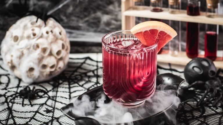 Spooky bloody sea breeze cocktail, served in a beautiful glass. Placed in a smoking black bowl.